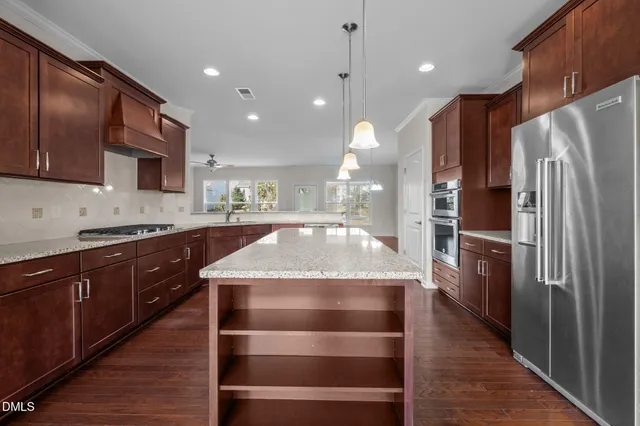 a view of a room wooden floor and kitchen view