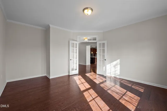 a view of a hallway with wooden floor and a kitchen