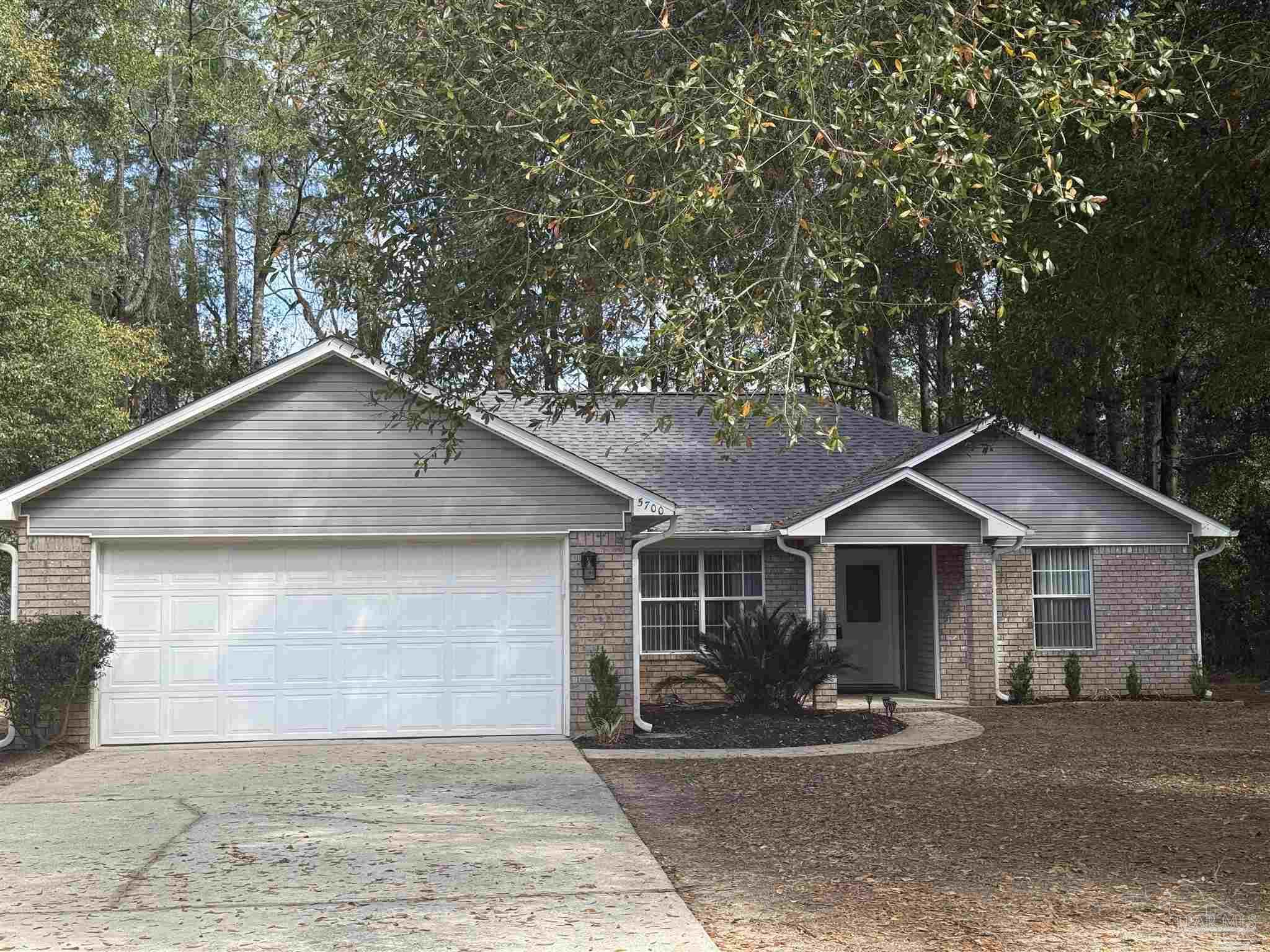 5700 Charmonte Way Milton, FL 32583 - Photo 1 of 29 a front view of a house with a garden and yard