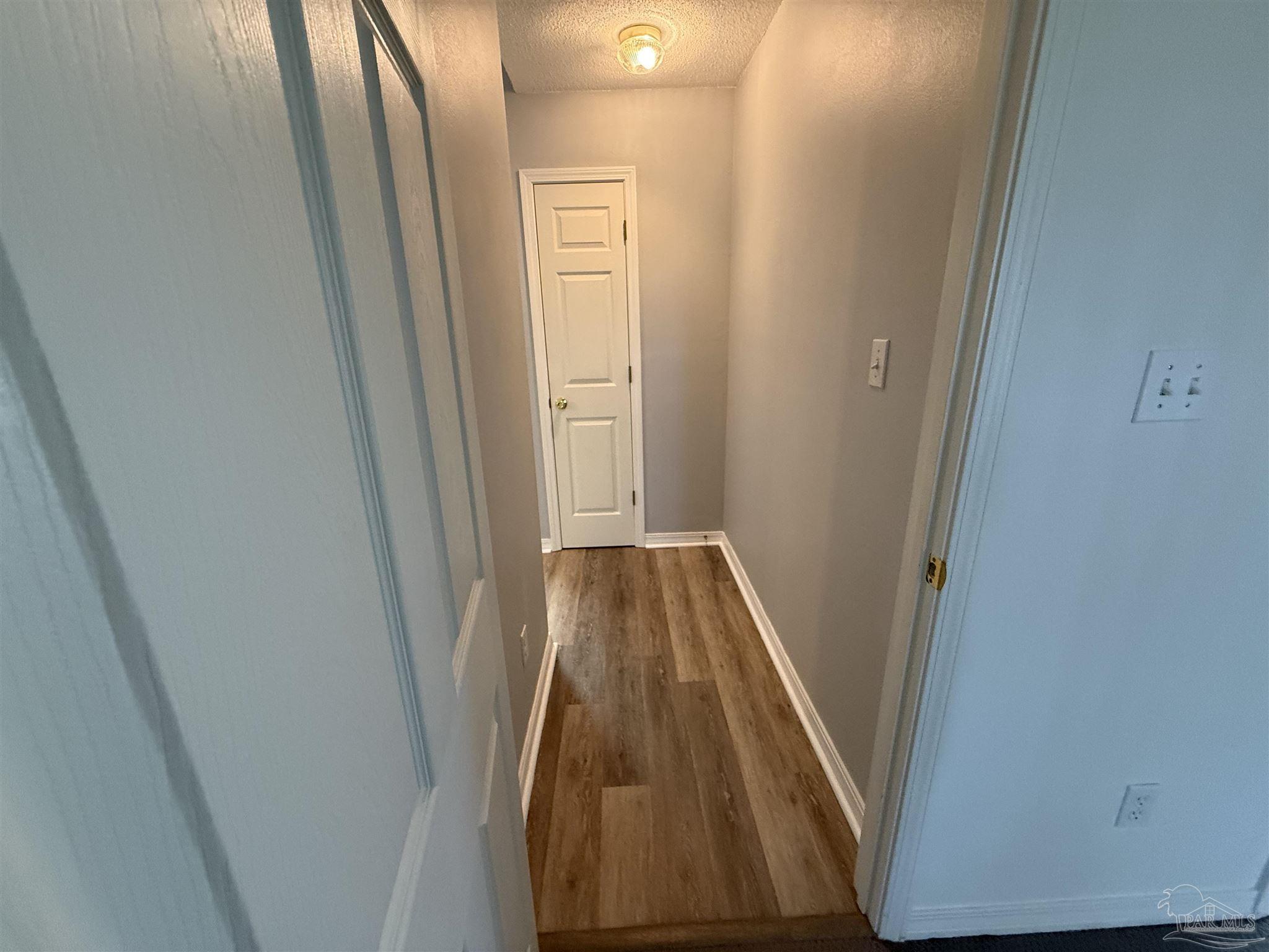 5700 Charmonte Way Milton, FL 32583 - Photo 19 of 29 a view of a hallway with wooden floor