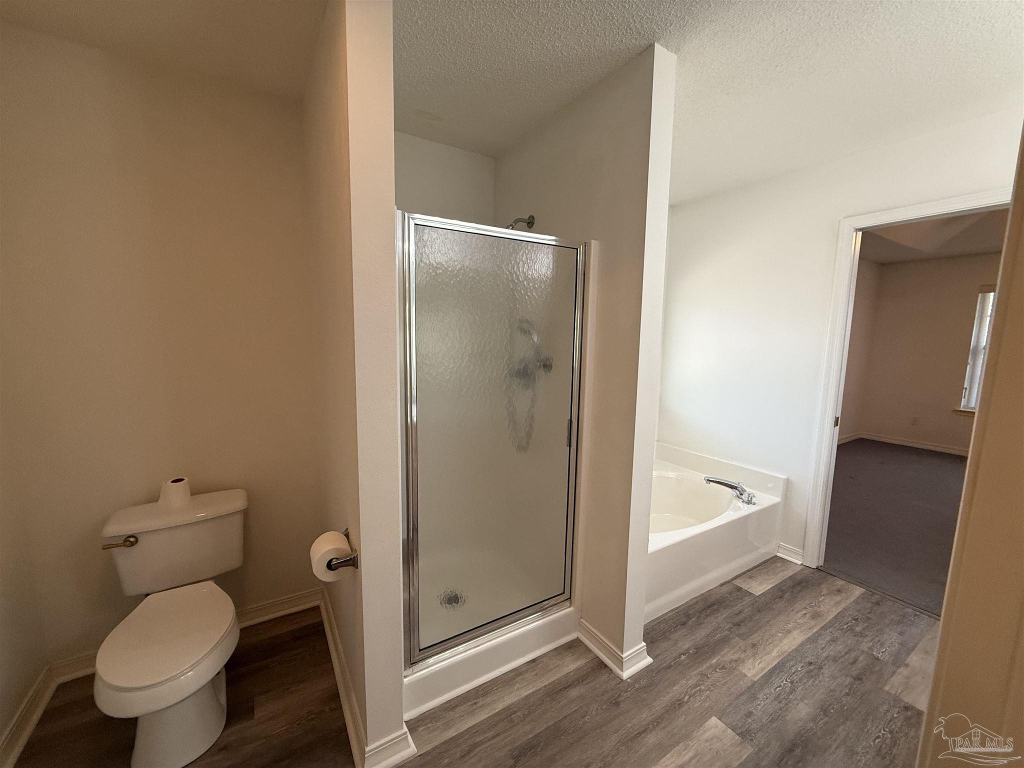 5700 Charmonte Way Milton, FL 32583 - Photo 26 of 29 a bathroom with a granite countertop toilet and a shower