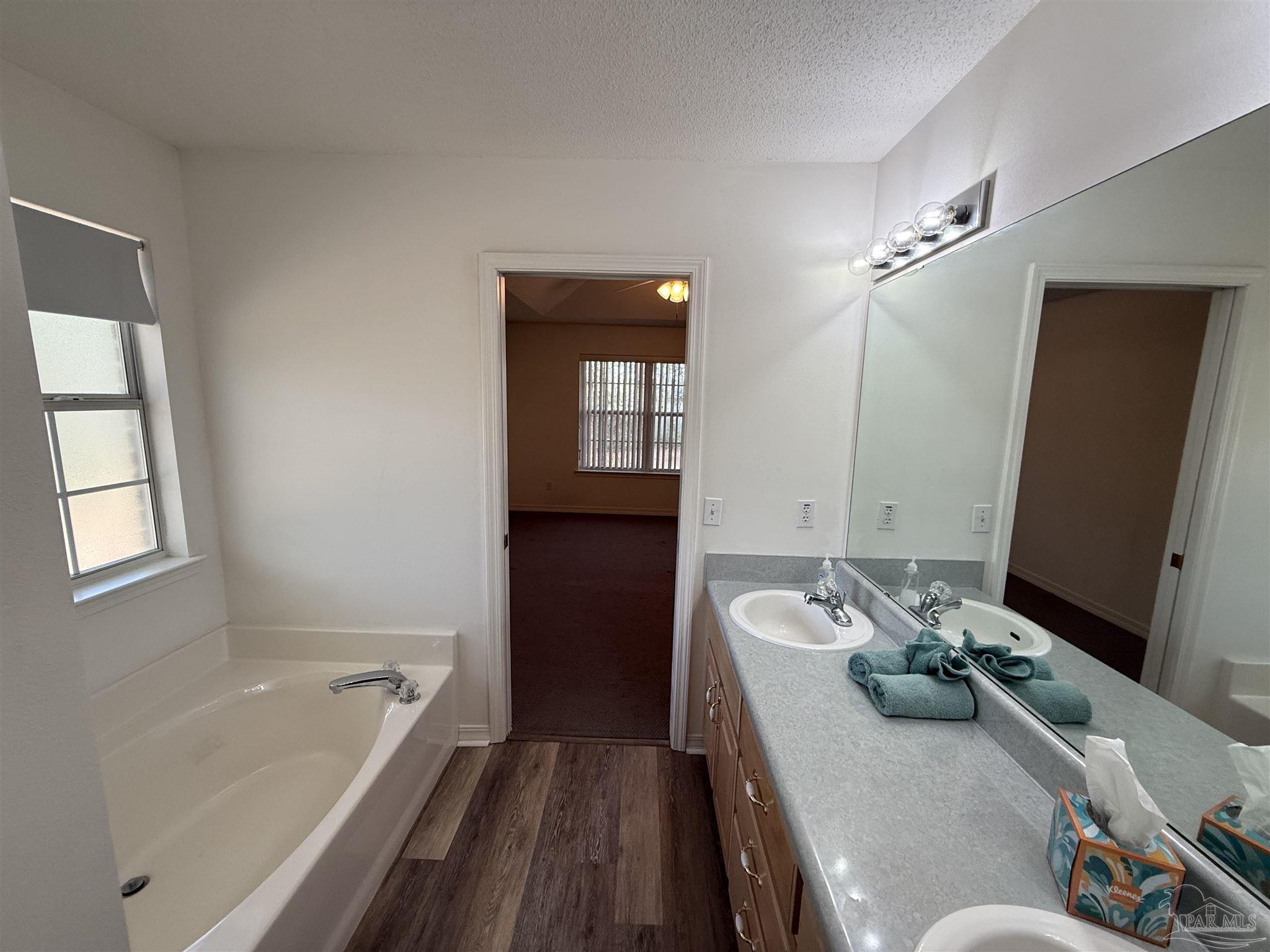 5700 Charmonte Way Milton, FL 32583 - Photo 28 of 29 a bathroom with a tub sink and mirror