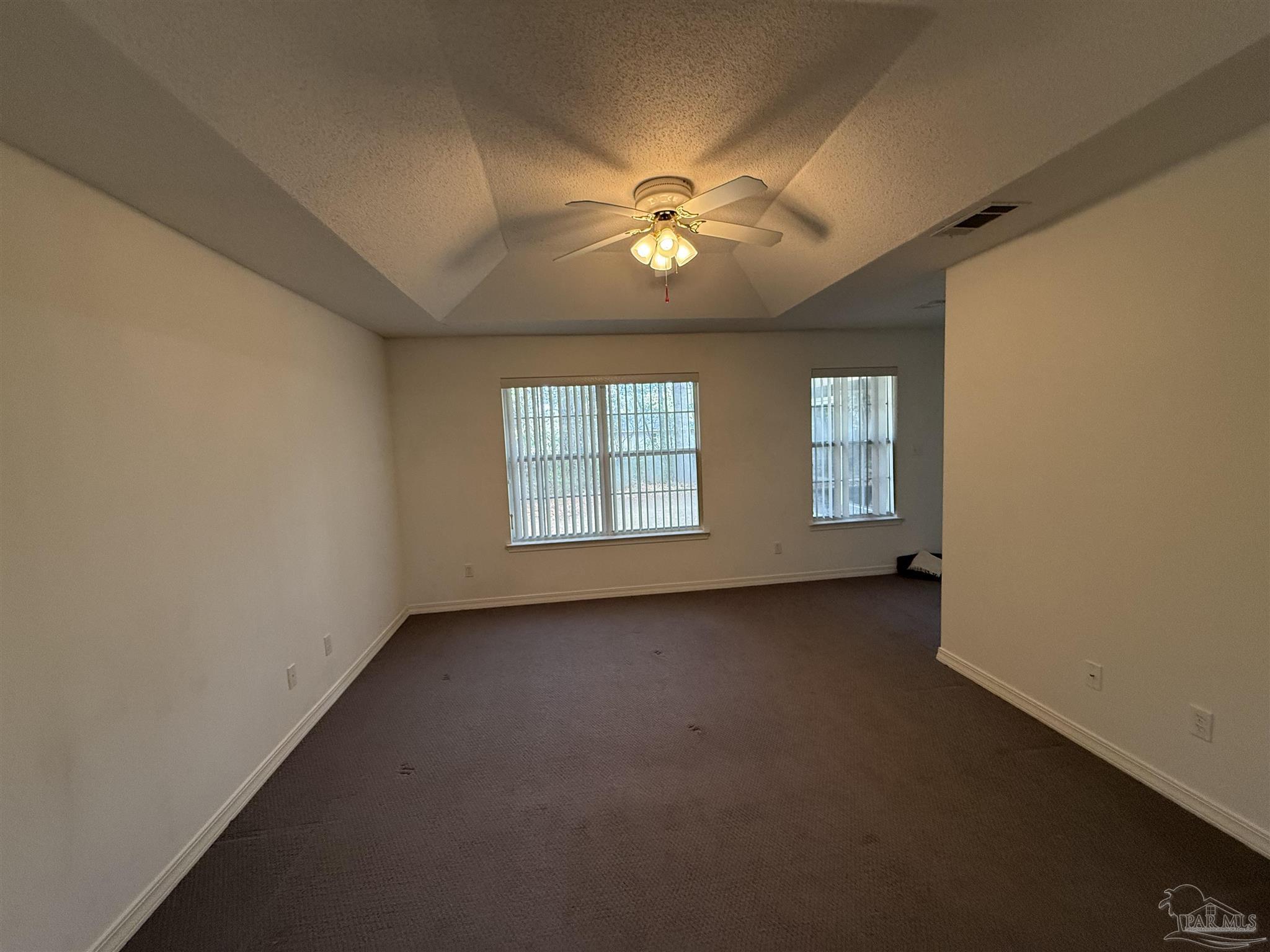 5700 Charmonte Way Milton, FL 32583 - Photo 29 of 29 an empty room with chandelier fan and windows