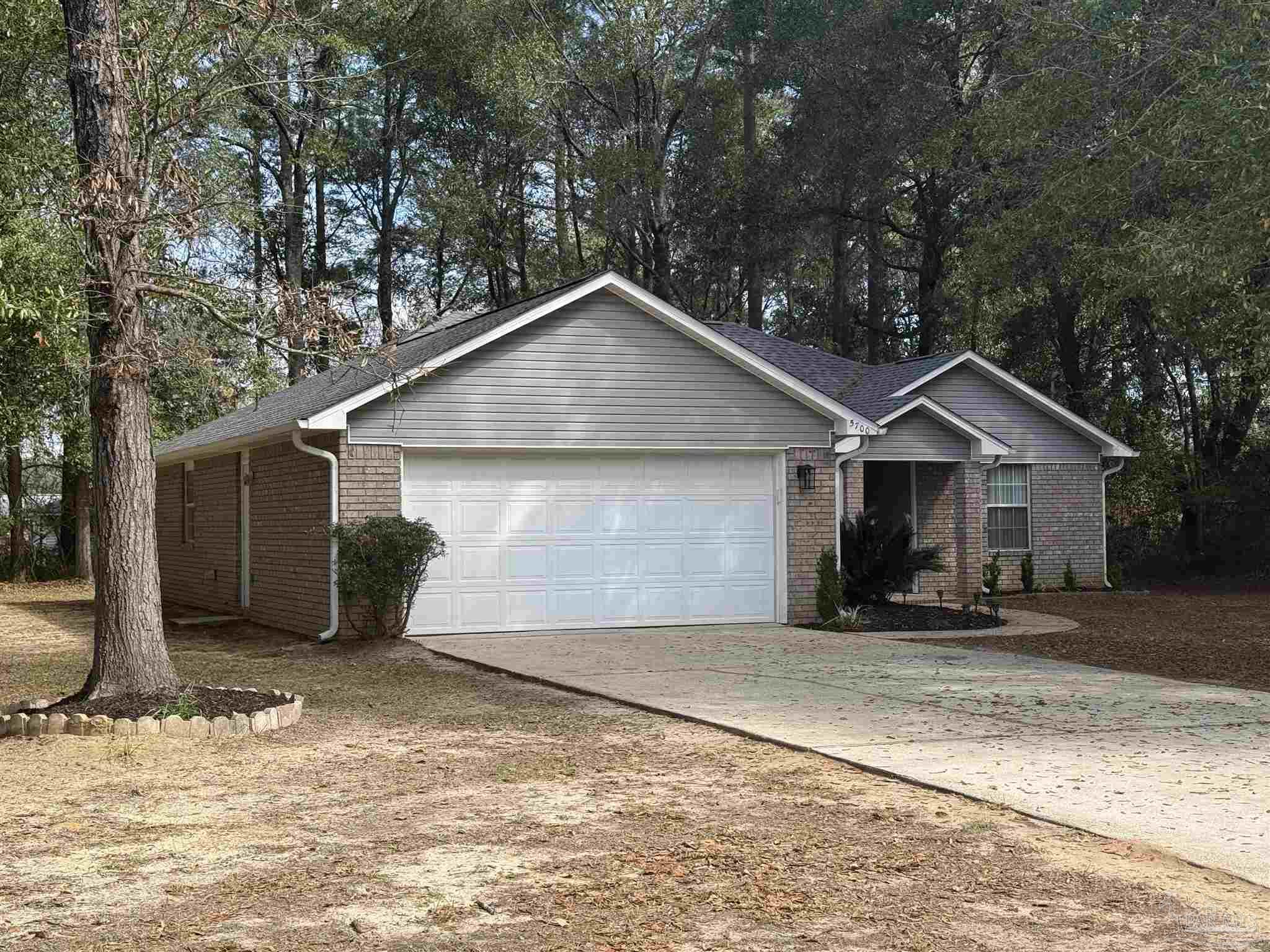 5700 Charmonte Way Milton, FL 32583 - Photo 3 of 29 a front view of a house with a yard and garage