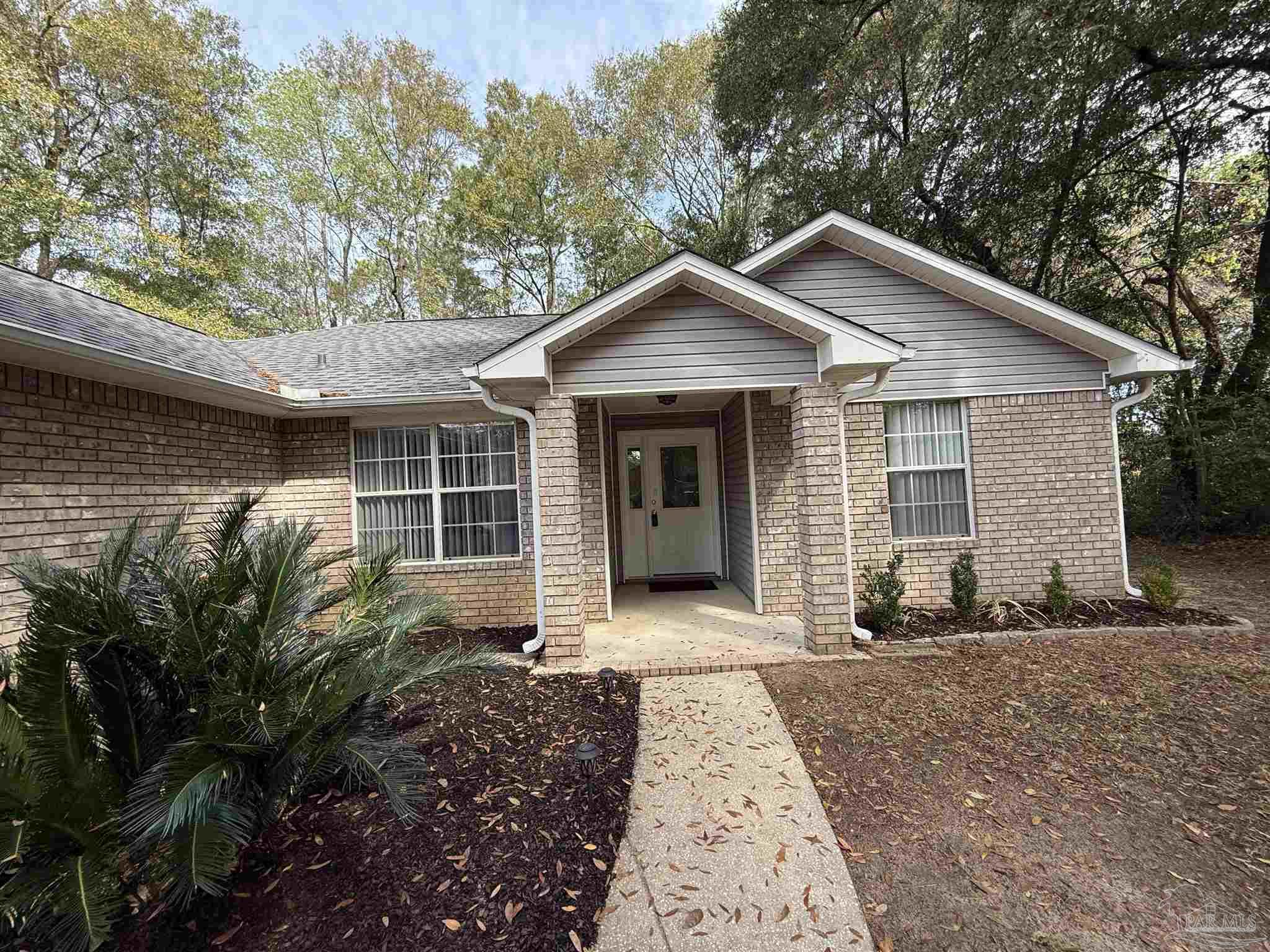 5700 Charmonte Way Milton, FL 32583 - Photo 5 of 29 a front view of a house with garden