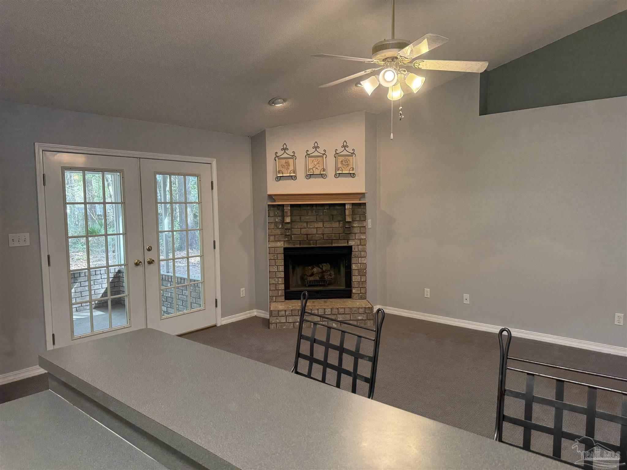 5700 Charmonte Way Milton, FL 32583 - Photo 6 of 29 a living room with furniture a fireplace and a chandelier