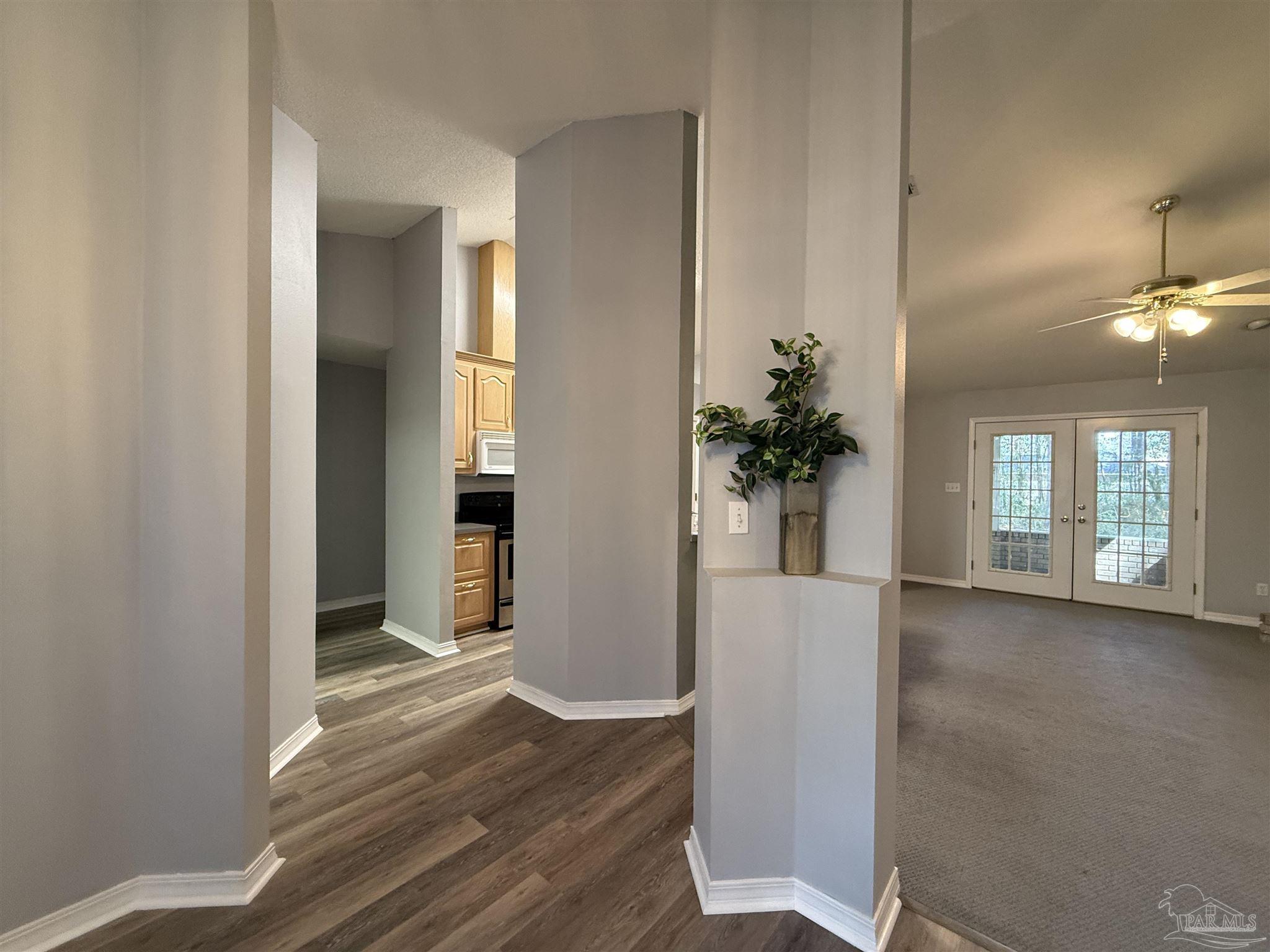 5700 Charmonte Way Milton, FL 32583 - Photo 7 of 29 a view of a hallway with wooden floor and a living room
