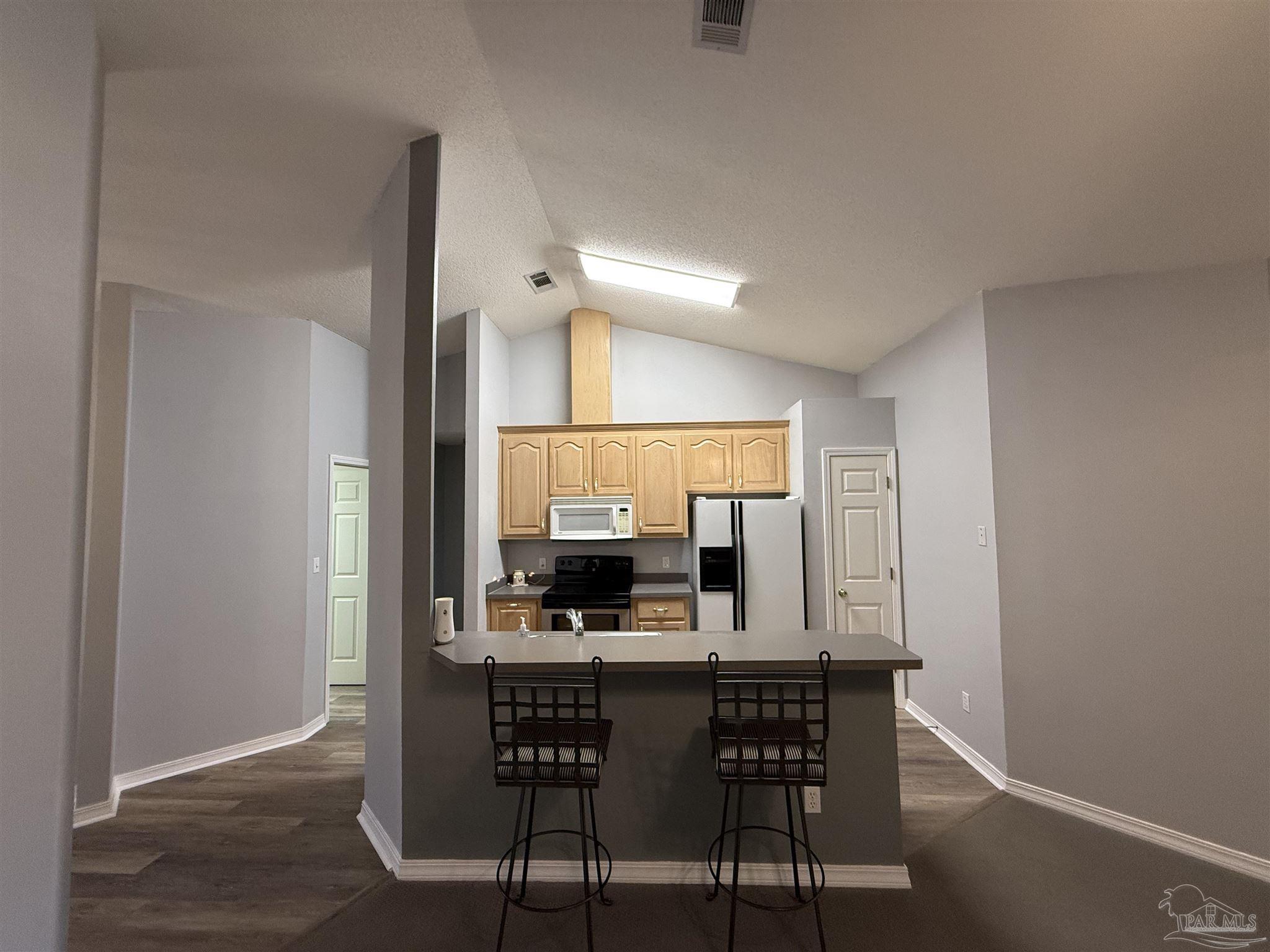5700 Charmonte Way Milton, FL 32583 - Photo 10 of 29 a view of a kitchen with a dining table and chairs