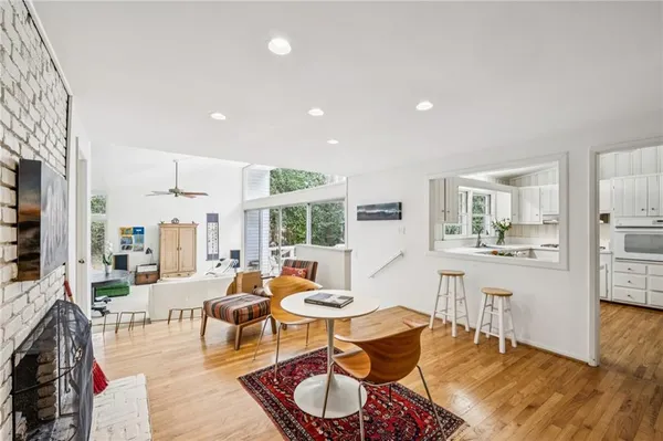a living room with furniture and a dining table with wooden floor