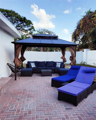 a view of a patio with table and chairs with wooden floor and fence