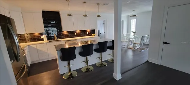 a kitchen with stainless steel appliances granite countertop a sink and a refrigerator