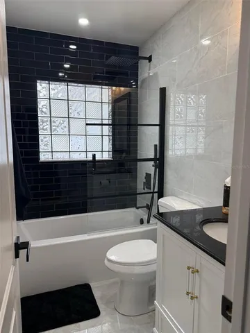 a bathroom with a sink a toilet a mirror and bathtub