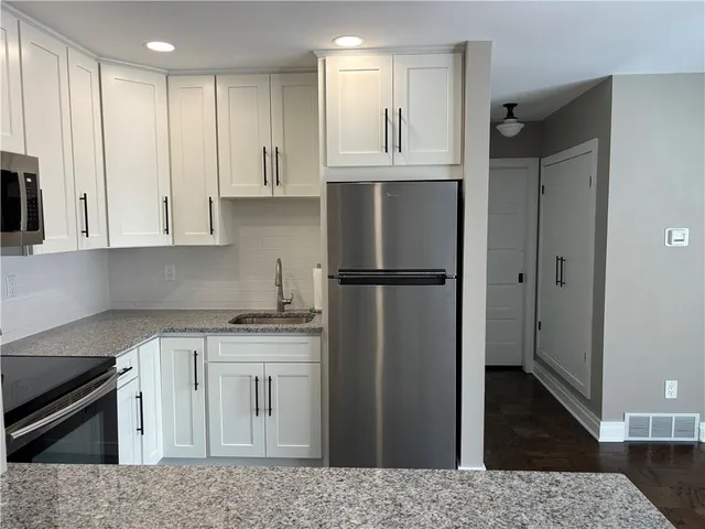 a kitchen with a stove a refrigerator and a sink