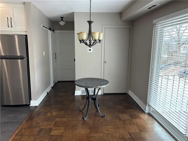 a view of a room with a cabinet and a chandelier
