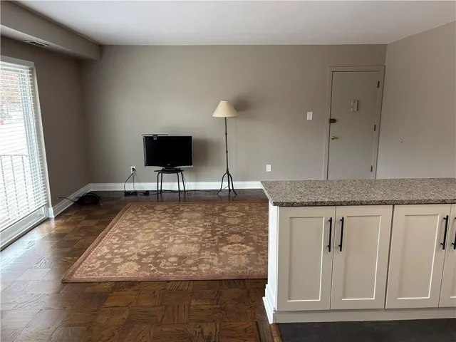 a view of living room with granite countertop wooden floor and white floor