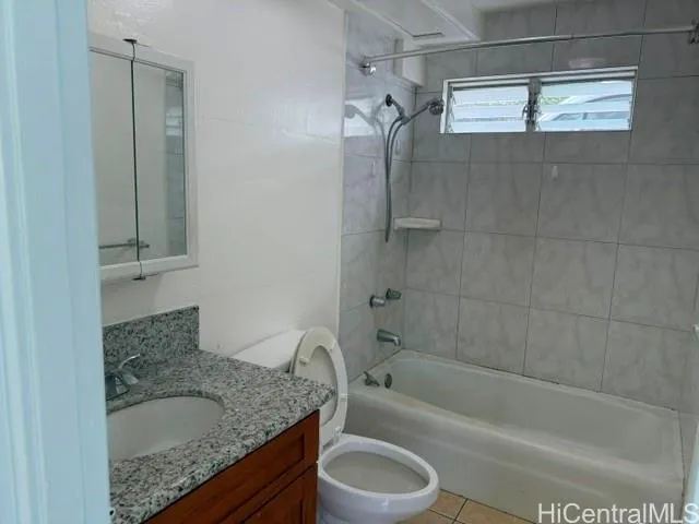 a bathroom with a granite countertop sink a toilet and bathtub