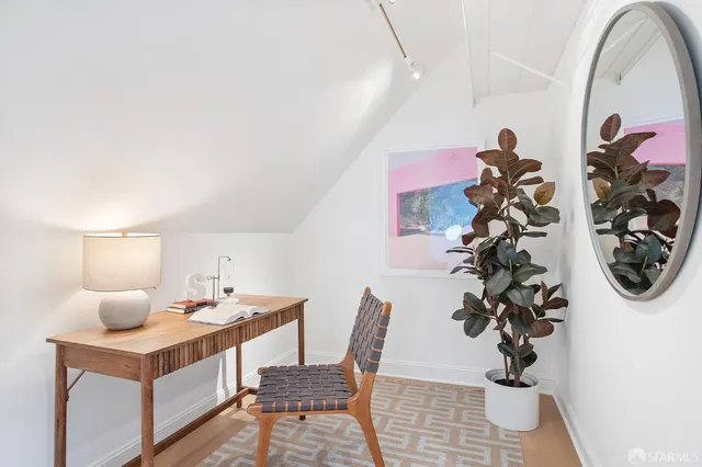 a dining room with furniture and a potted plant