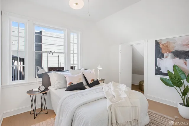 a bedroom with a bed and a potted plant
