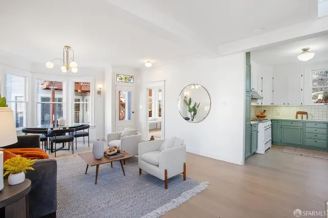 a living room with furniture a rug and kitchen view