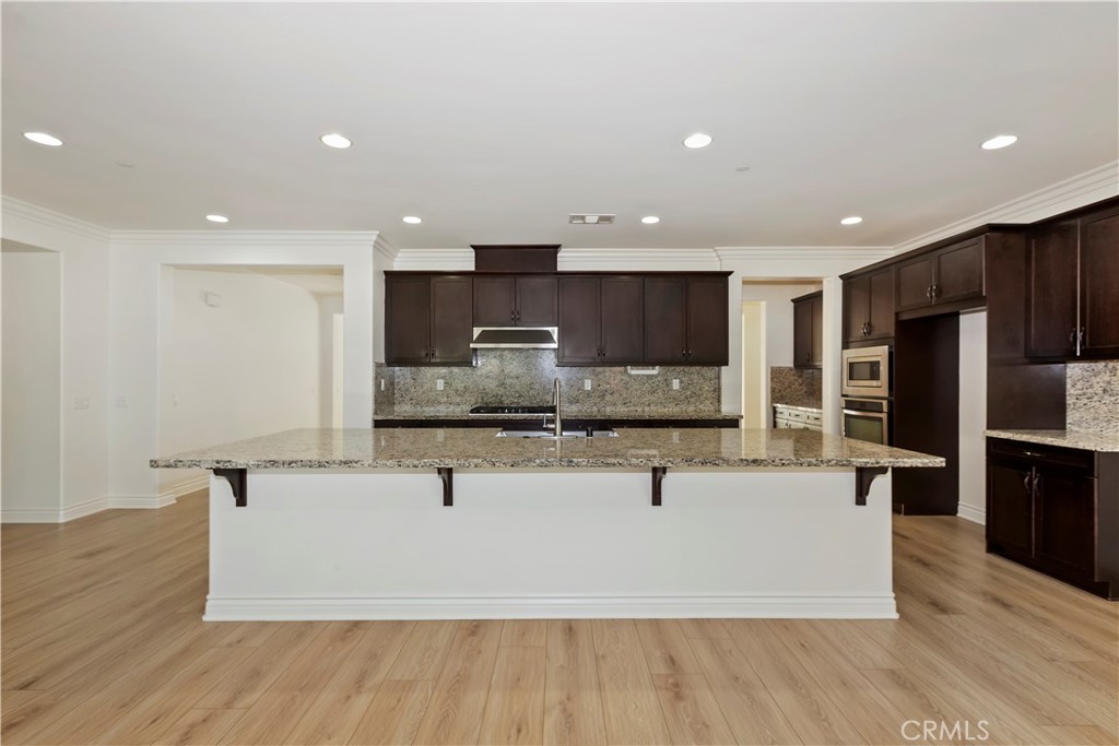 6336 Sloane Court Rancho Cucamonga, CA 91739 - Photo 21 of 69 a large kitchen with stainless steel appliances a large counter top a stove and a refrigerator