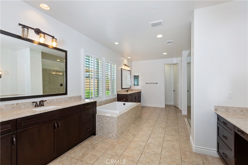 6336 Sloane Court Rancho Cucamonga, CA 91739 - Photo 29 of 69 a large bathroom with a double vanity sink a mirror and a shower