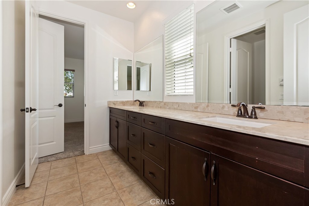 6336 Sloane Court Rancho Cucamonga, CA 91739 - Photo 36 of 69 a bathroom with a sink double vanity granite tub shower and a mirror