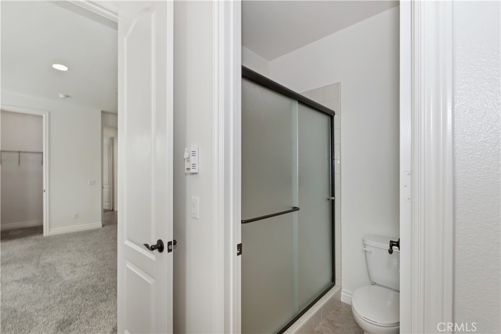 6336 Sloane Court Rancho Cucamonga, CA 91739 - Photo 37 of 69 a bathroom with a granite countertop toilet and a shower