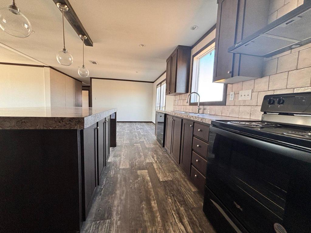 149 Castellana Way Elgin, TX 78621 - Photo 5 of 18 a kitchen with stainless steel appliances granite countertop a stove a sink and a refrigerator
