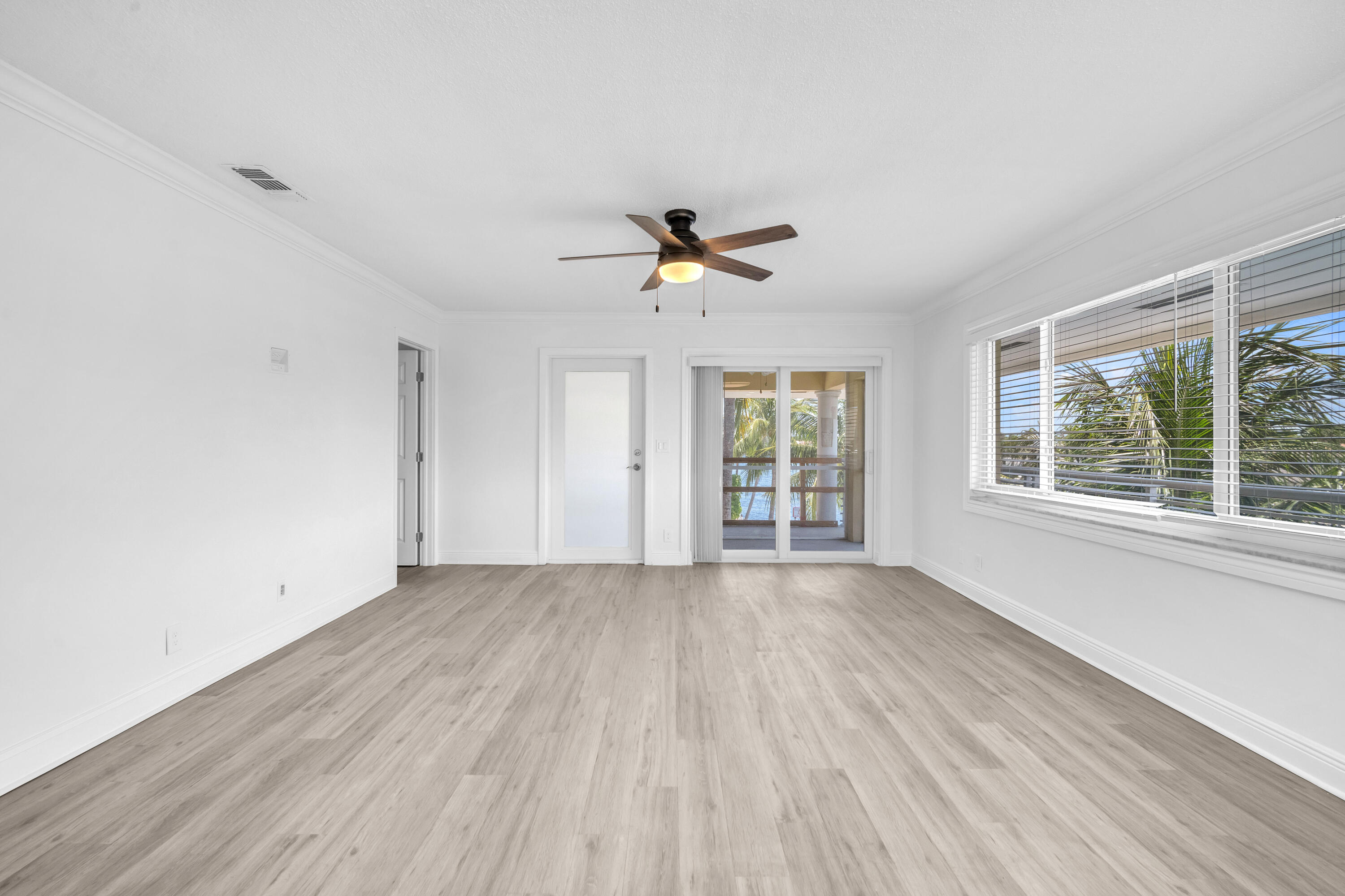 1015 Spanish River Road Boca Raton, FL 33432 - Photo 13 of 28 an empty room with wooden floor and windows