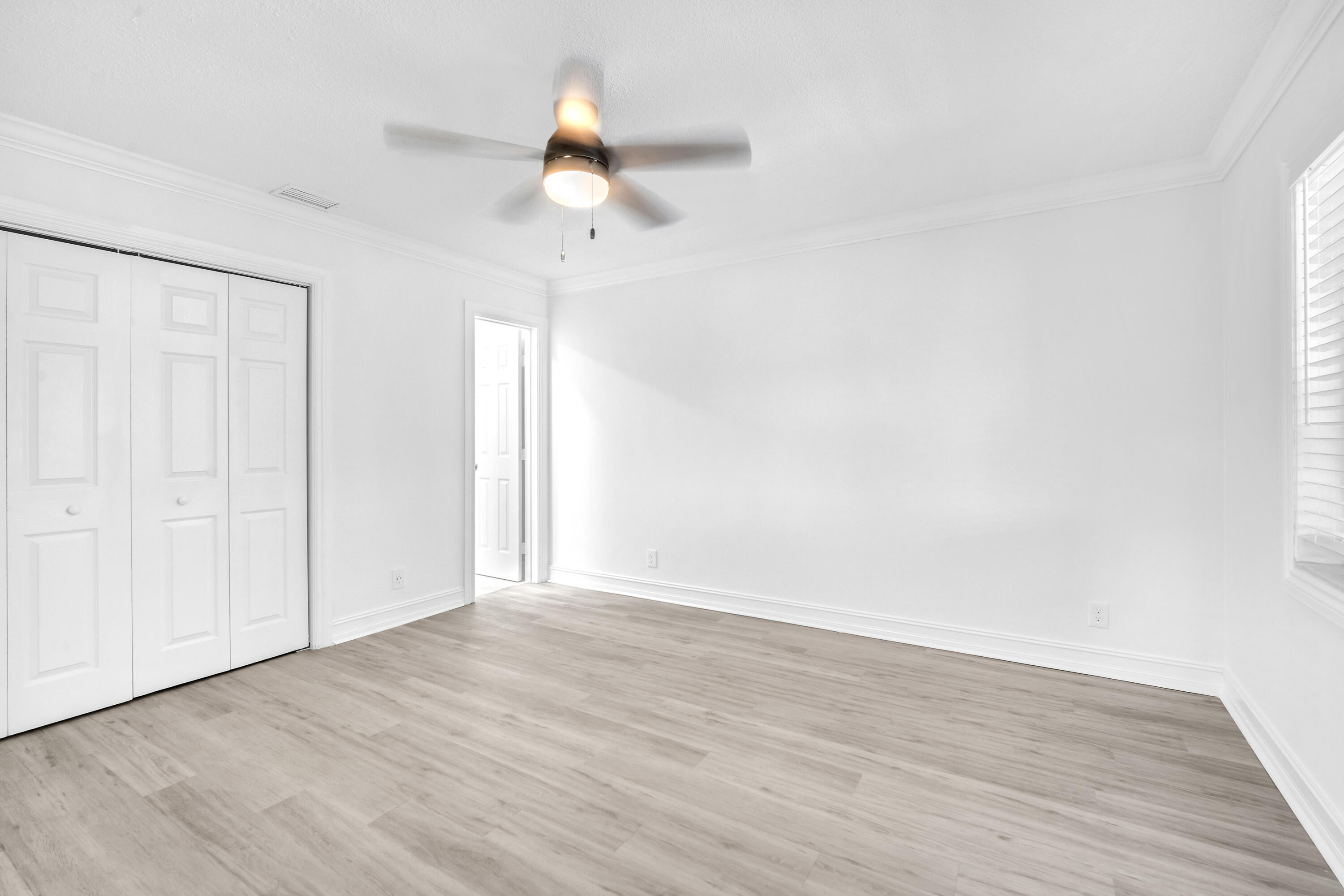 1015 Spanish River Road Boca Raton, FL 33432 - Photo 14 of 28 a view of an empty room with wooden floor and a window
