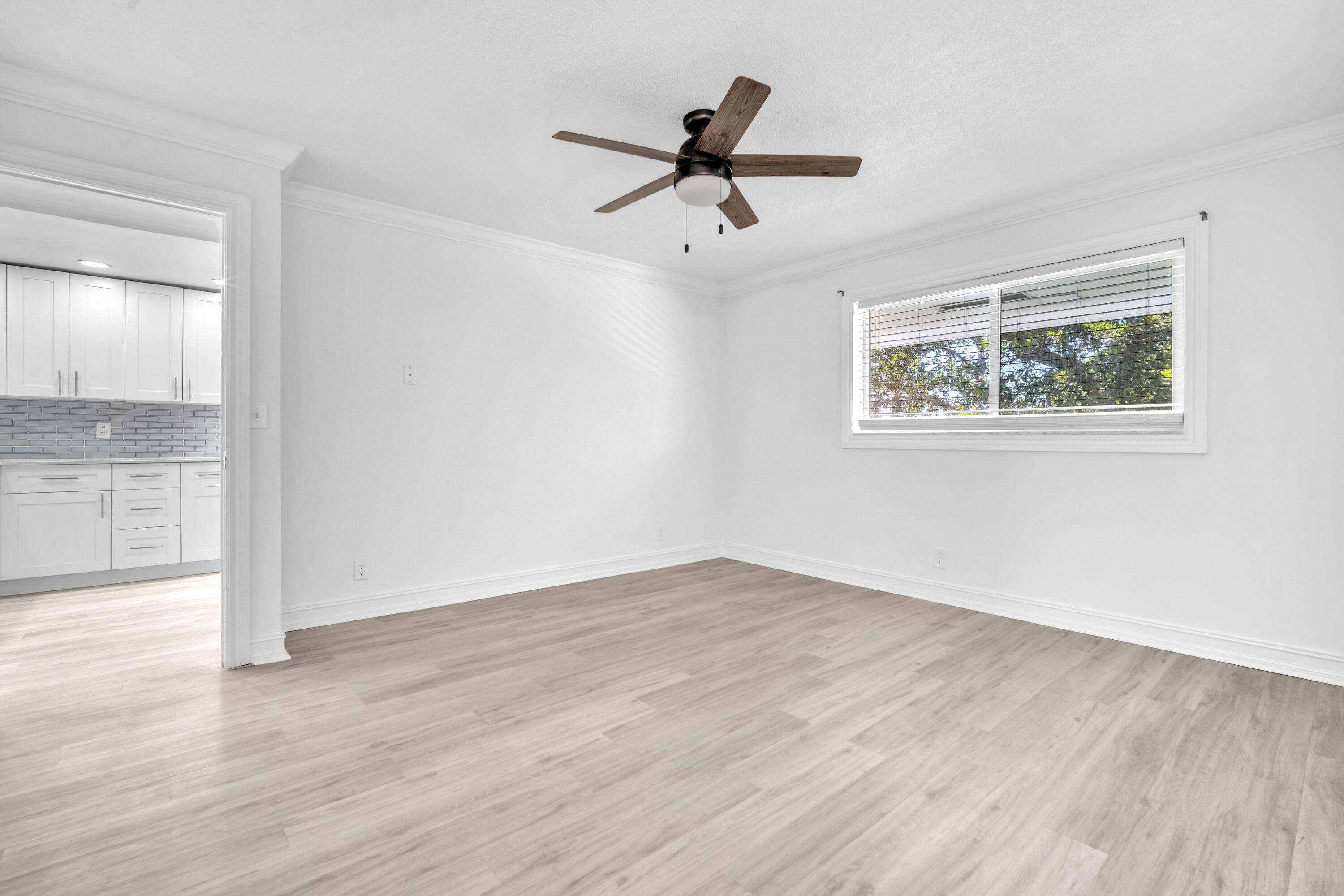 1015 Spanish River Road Boca Raton, FL 33432 - Photo 18 of 28 a view of an empty room with wooden floor and a ceiling fan