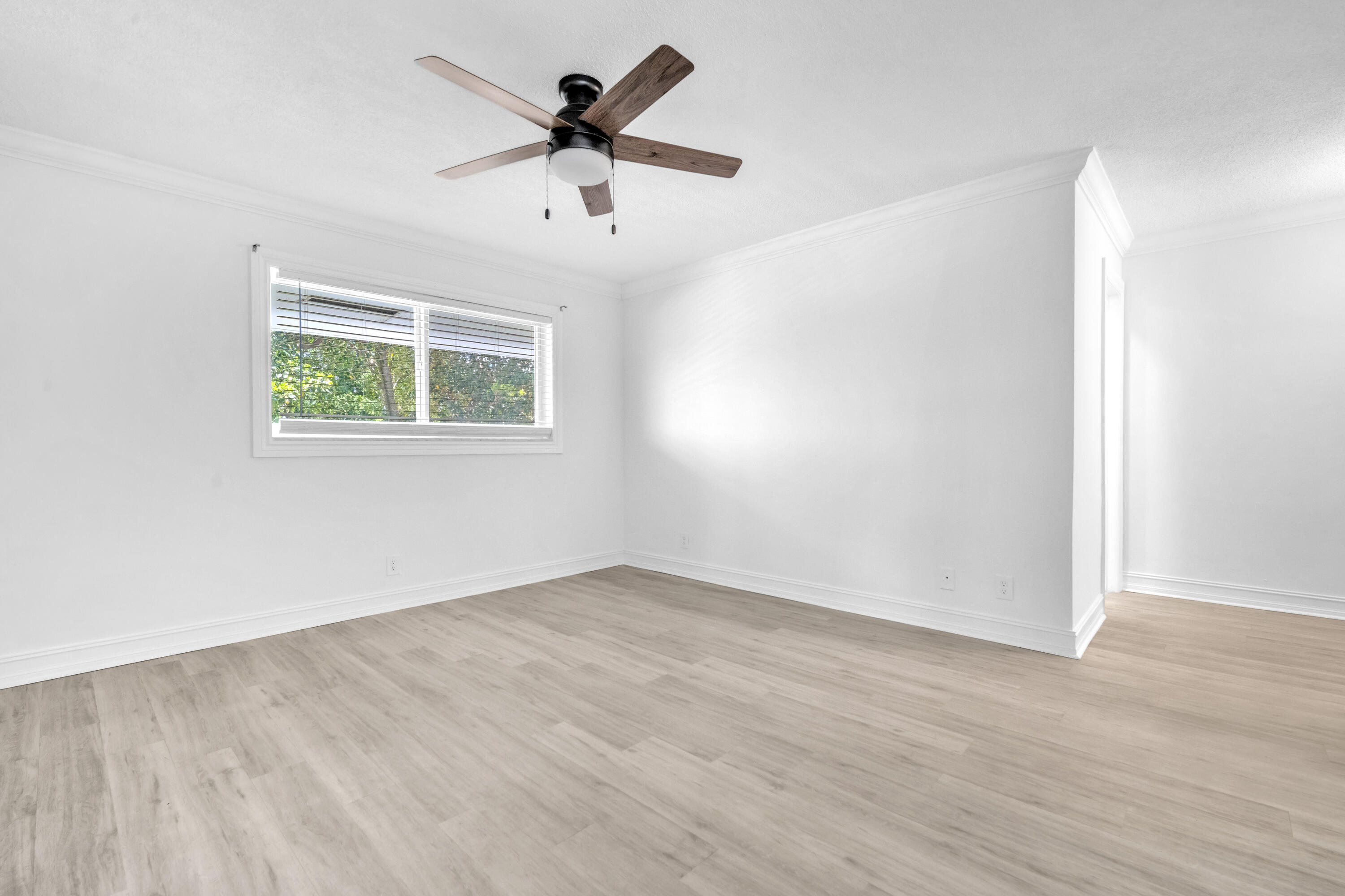 1015 Spanish River Road Boca Raton, FL 33432 - Photo 19 of 28 an empty room with wooden floor and windows