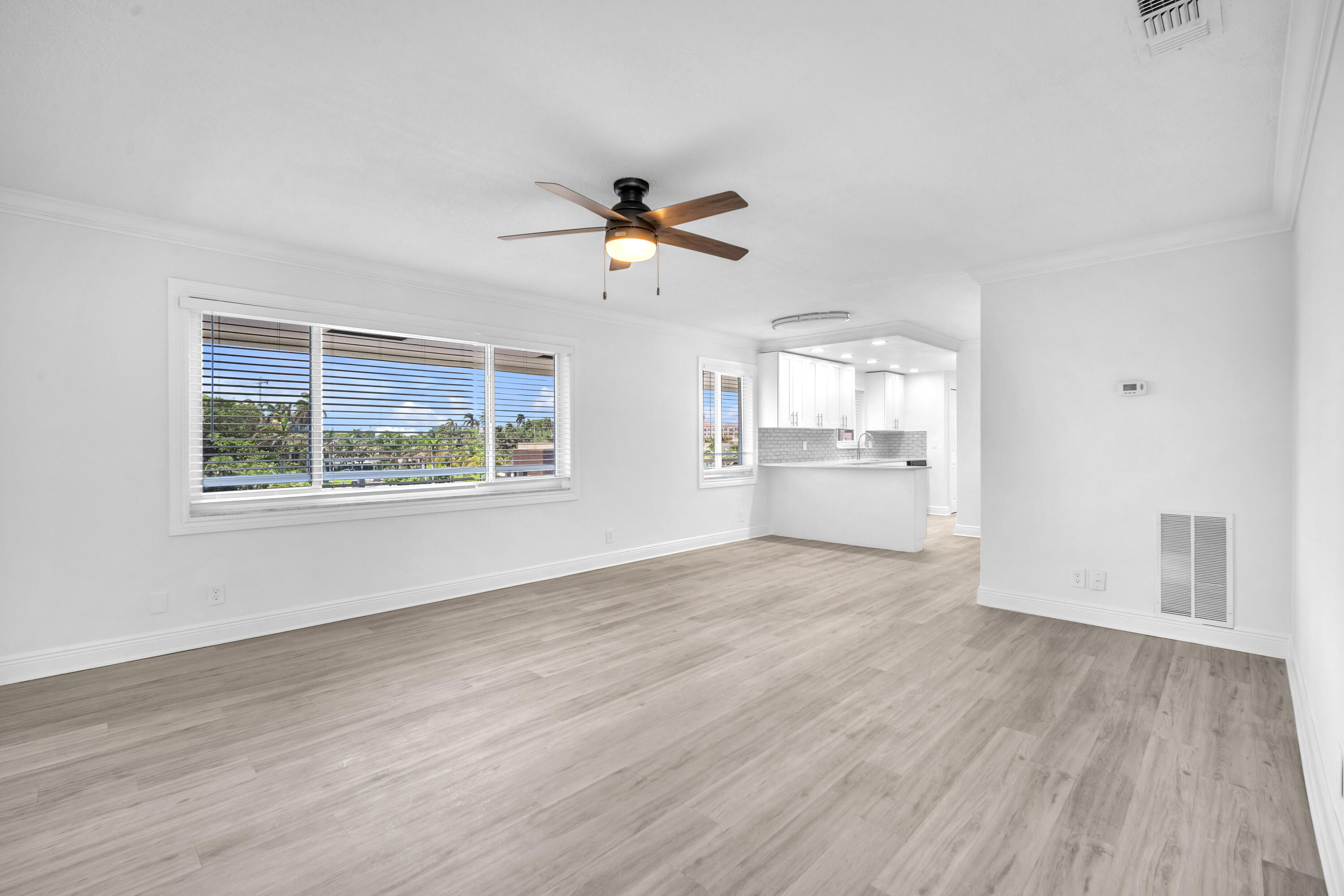 1015 Spanish River Road Boca Raton, FL 33432 - Photo 5 of 28 a view of an empty room with a window and wooden floor