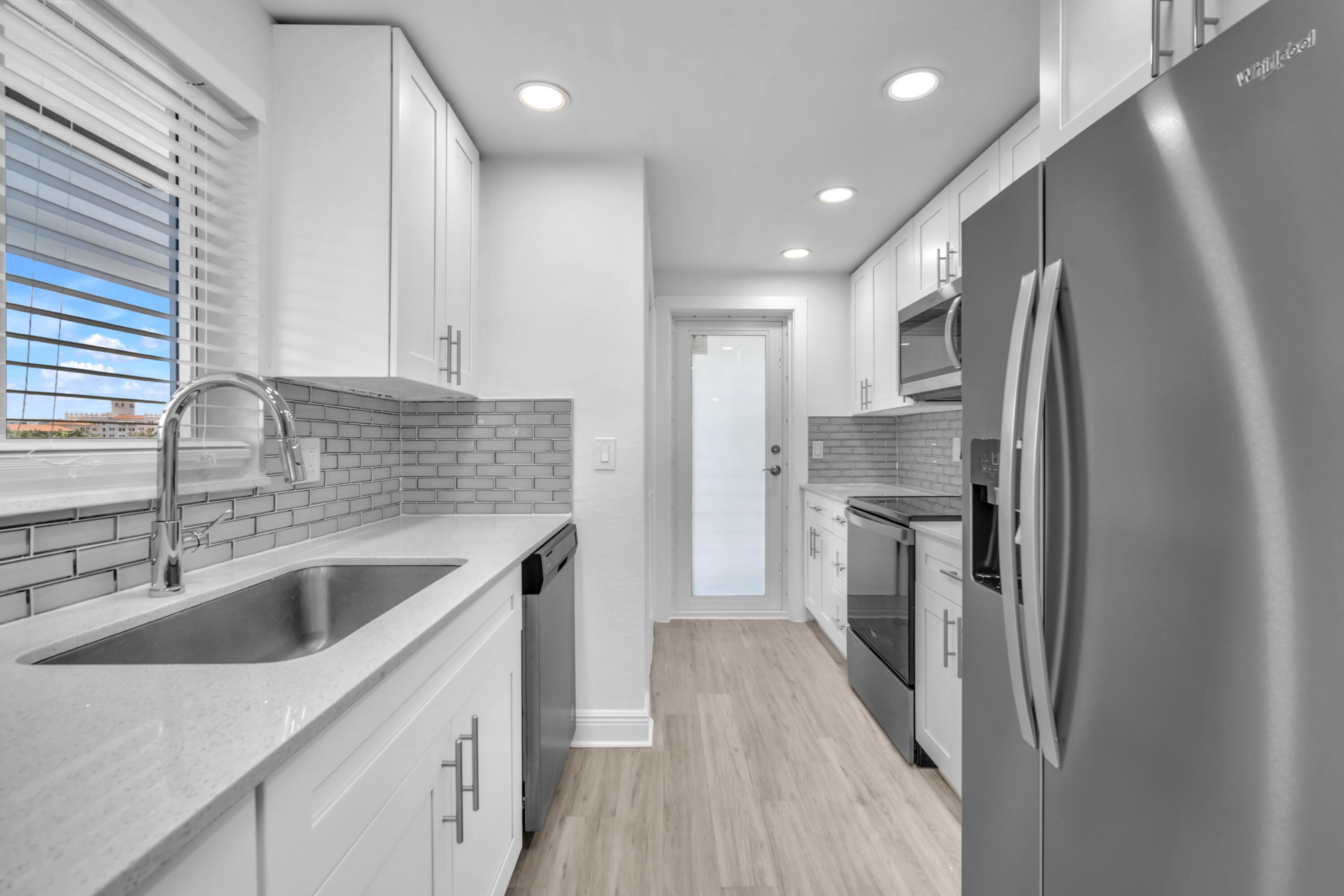 1015 Spanish River Road Boca Raton, FL 33432 - Photo 8 of 28 a kitchen with a sink a refrigerator and cabinets