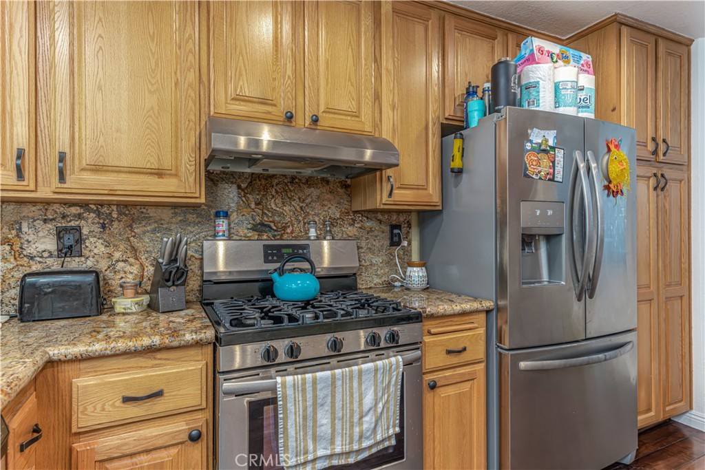 3730 South Bear Street, Unit E Santa Ana, CA 92704 - Photo 28 of 43 a kitchen with stainless steel appliances granite countertop a refrigerator sink and stove