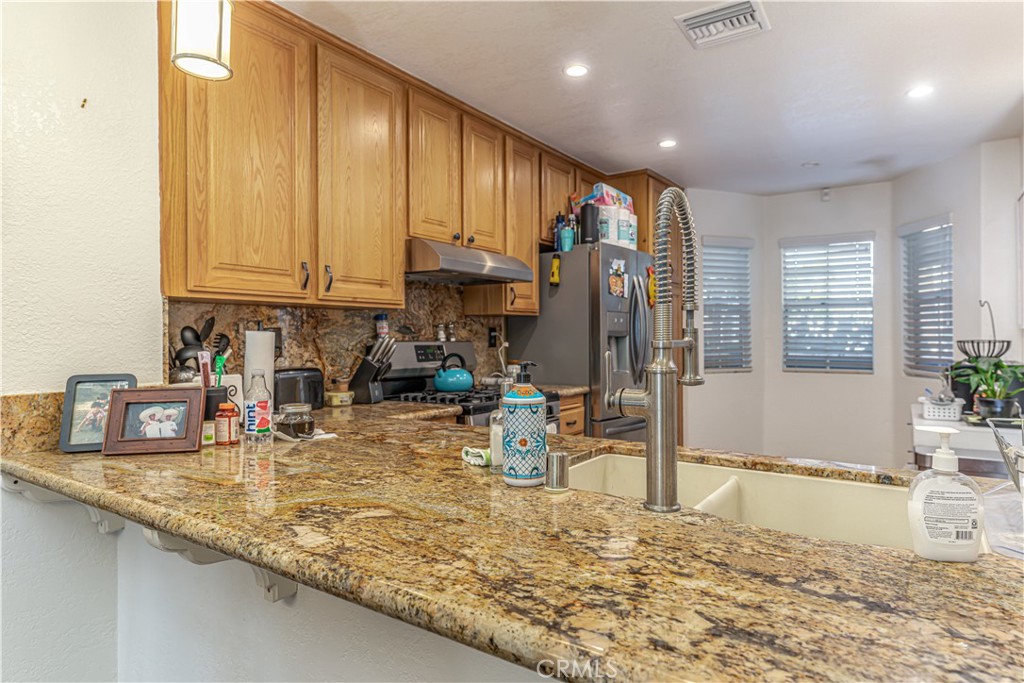 3730 South Bear Street, Unit E Santa Ana, CA 92704 - Photo 29 of 43 a kitchen with sink refrigerator and cabinets