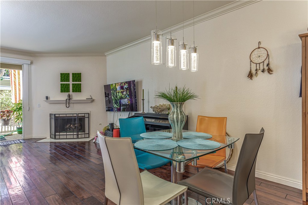 3730 South Bear Street, Unit E Santa Ana, CA 92704 - Photo 7 of 43 a dining room with furniture wooden floor a fireplace and a potted plant
