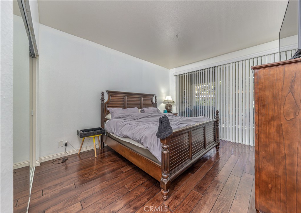 3730 South Bear Street, Unit E Santa Ana, CA 92704 - Photo 8 of 43 a bedroom with a bed and wooden floor