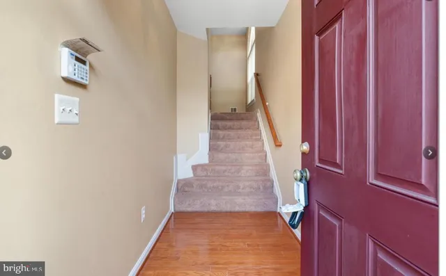 a view of a hallway with wooden floor and entryway