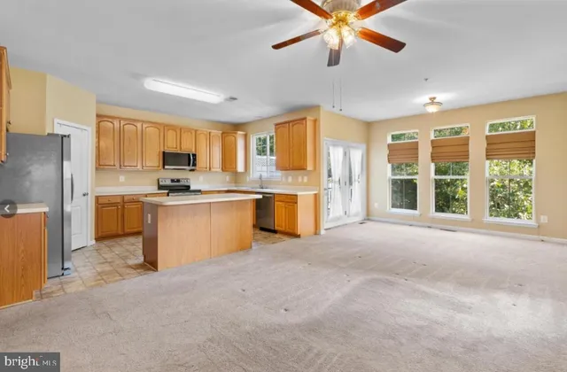 a kitchen with stainless steel appliances granite countertop a stove a refrigerator a sink a oven with a dining table and chairs