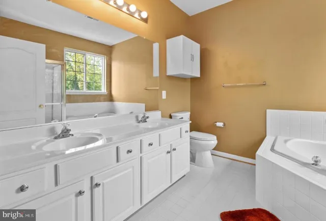 a bathroom with a granite countertop sink mirror vanity and a toilet