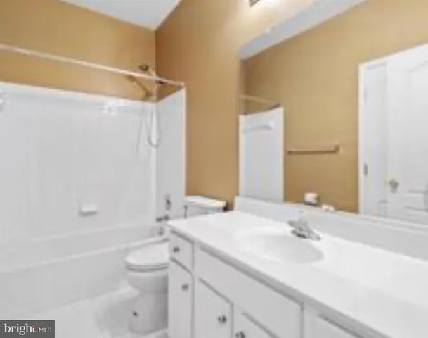 a bathroom with a granite countertop sink a toilet and shower