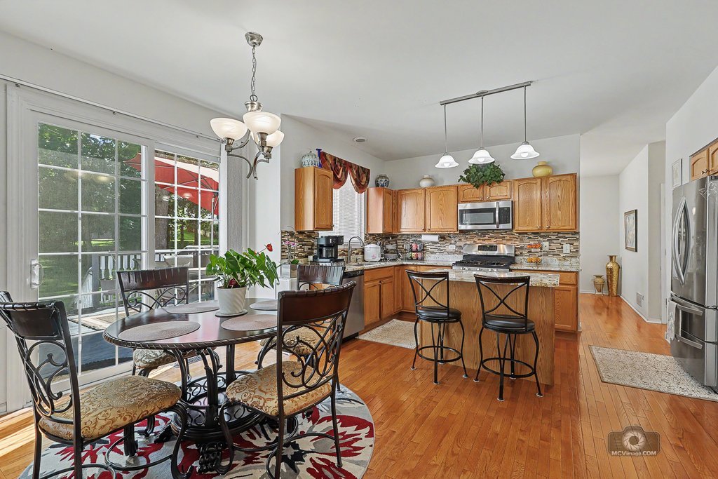 483 Elm Ridge Road Carpentersville, IL 60110 - Photo 9 of 31 a dining room filled chandelier and wooden floor