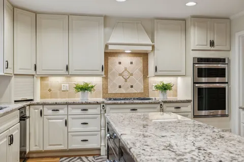a living room with furniture a flat screen tv and a chandelier