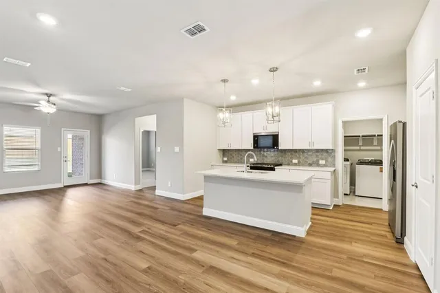 a view of kitchen with refrigerator stove and wooden floor