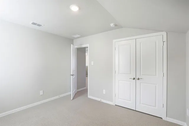 an empty room with white cabinet and closet
