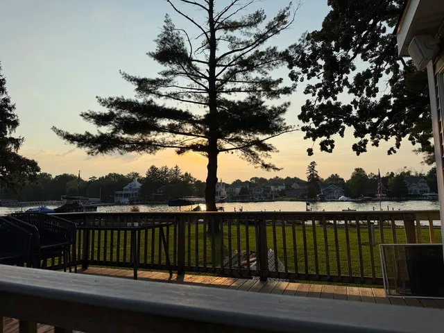 a front view of a house with a garden and trees