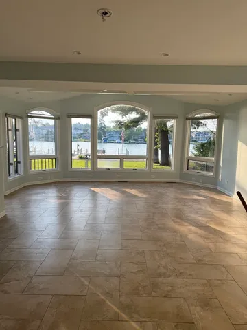 a view of an empty room with window and a living room