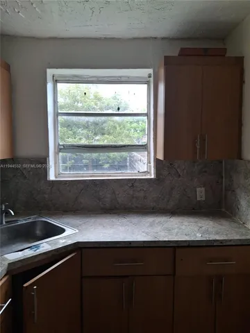 a kitchen with a sink a window and cabinets