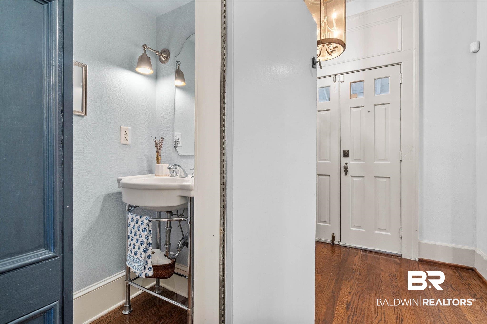 3863 Old Shell Road Mobile, AL 36608 - Photo 8 of 48 White pedestal sink with chrome faucet, light blue wall paint, and wall-mounted sconces